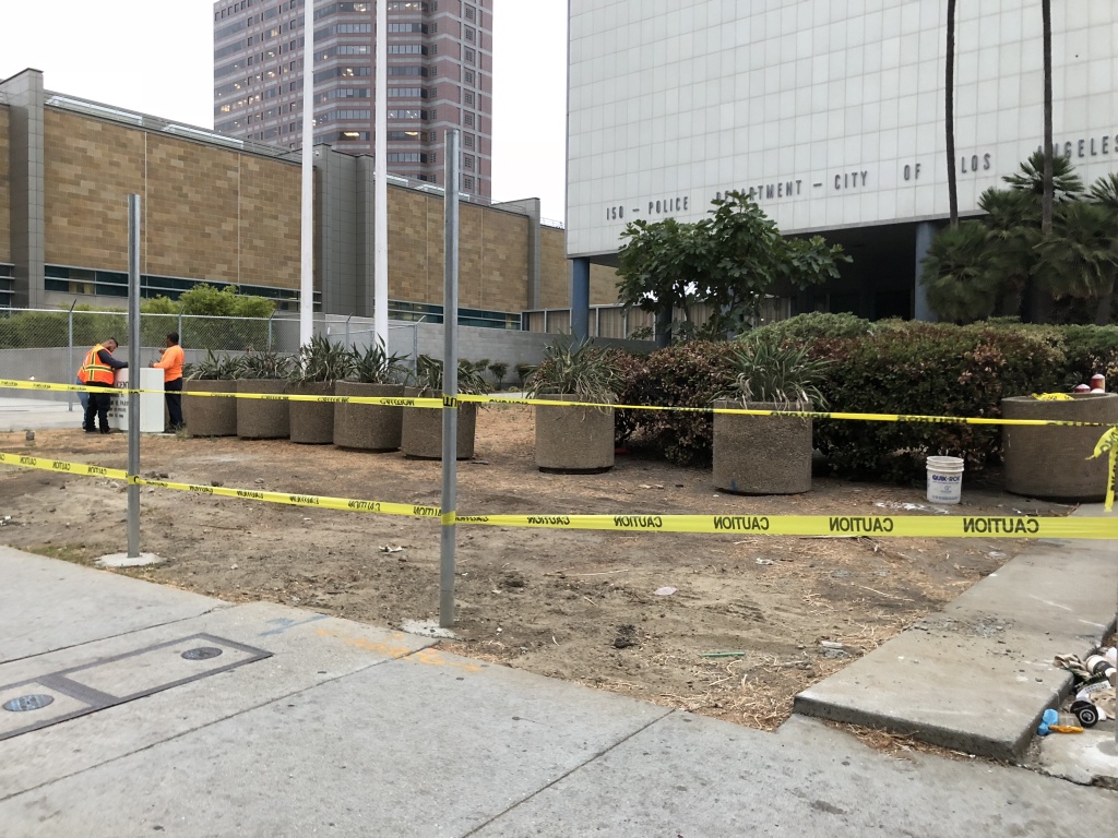 Workers build a temporary chain-link fence around the construction site to prepare for demolition. Workers build a temporary chain-link fence around the construction site to prepare for demolition.