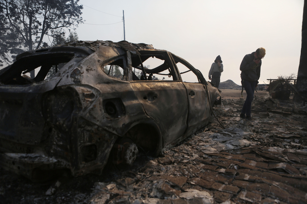 Ventura County Thomas Fire Forces Thousands to Evacuate Residents walk amidst the remains of an apartment complex destroyed by the Thomas Fire in a residential neighborhood on Dec. 5, 2017 in Ventura.