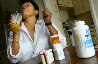 Alba Cerrato swallows some of her 14 different AIDS medications that she takes three times a day July 11, 2002 in Miami, Florida.
