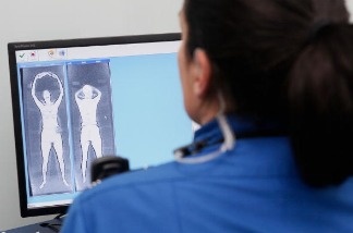 A Transportation Security Administration (TSA) worker demonstrates the monitoring station which will be used with full-body scanners.