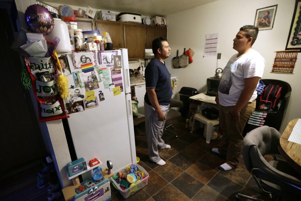 Immigrant Children Asylum Alejandro Lopez, of Des Moines, Iowa, left, talks with his son Jonathan about his application for asylum, Tuesday, May 10, 2016, in Clive, Iowa. For immigrant children seeking asylum in the U.S., where they apply seems to make a world of difference. (AP Photo/Charlie Neibergall)