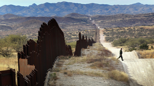 A Border Patrol agent looks for footprints from illegal immigrants crossing the U.S.- Mexico border in 2010. Traffickers have begun using immigrants as drug smugglers, recruiting voluntarily and forcibly.