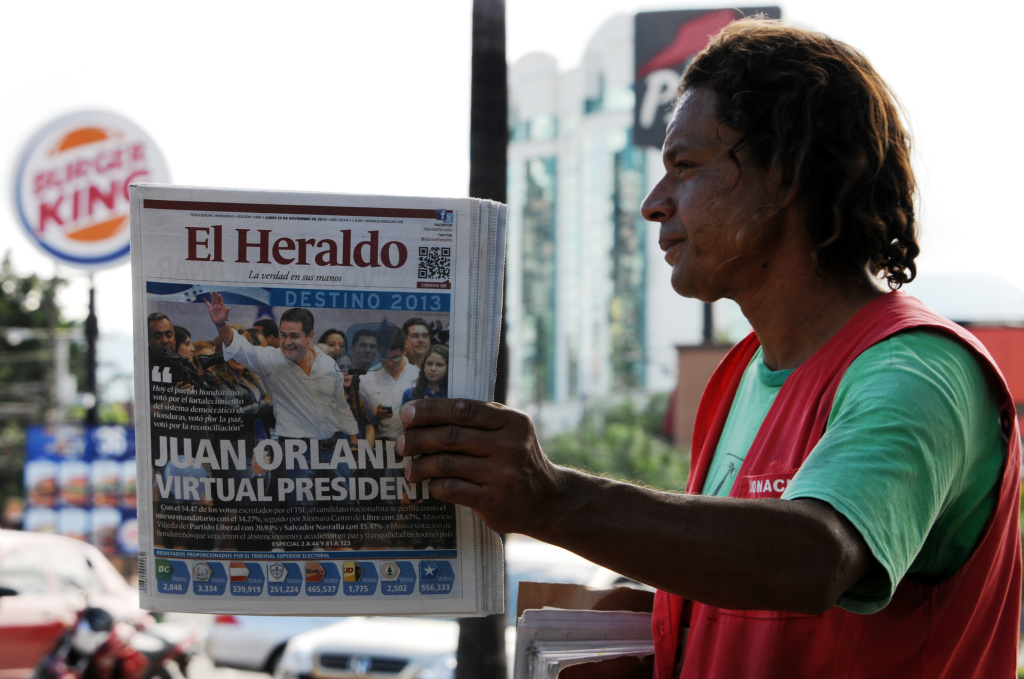 HONDURAS-ELECTION-AFTERMATH A street vendor sells newspapers in Tegucigalpa, on November 25, 2013, the day after general elections. Both leading presidential candidates in crime-wracked Honduras declared victory late Sunday, setting the stage for a possible round of street protests and violence in one the world's deadliest countries. With more than half the votes counted, conservative Juan Orlando Hernandez was ahead with 34 percent against 29 percent for leftist Xiomara Castro.