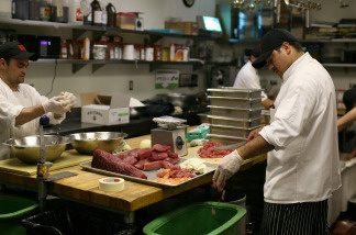 A cook drops fish skin and fat into a recycling container at MoMo's restaurant in San Francisco, California on April 21.