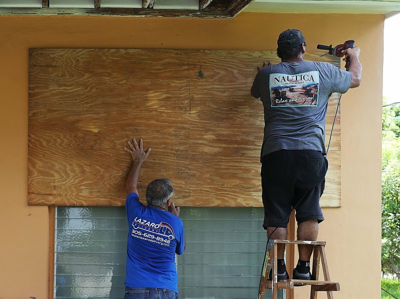 gettyimages-843387966-ecc0a7e69ff46b4e093af9ca8e107872ef6ce3c2-s800-c85.jpg Men put up shutters to prepare a house for Hurricane Irma on Wednesday in Miami.