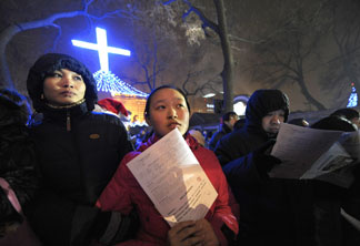 Chinese worshippers wait to enter a Catholic church for Christmas mass in Beijing on December 24, 2009.
