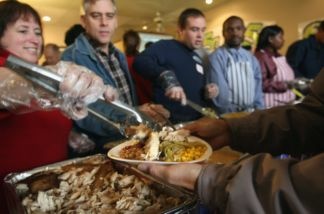 Mercer 12225 Volunteers dish out Thanksgiving dinner to the needy during a free banquet prepared at Smokey Jackson's Boneyard grill in Aurora, Colorado. Homeless and disadvantaged people were transported to the event by Christian aid groups, whose members helped serve the meal.