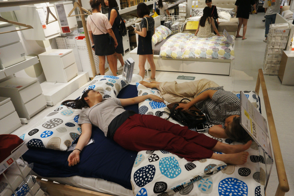 CHINA-LIFESTYLE-WEATHER People nap on a bed at an Ikea store to escape the heat outside in Hangzhou, in China's eastern Zhejiang province on July 24, 2017.