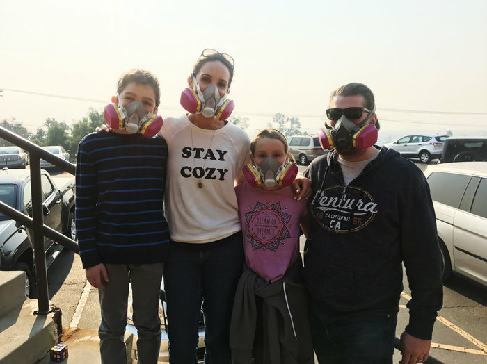 After a wildfire, celebrating Christmas among the ashes Nancy and Jay Blomquist stand outside the Local Assistance Center in Ventura, Calif. with their twins Alexander and Olivia. The family wears masks to protect themselves from the ash and smoke in the air from thee Thomas fire.