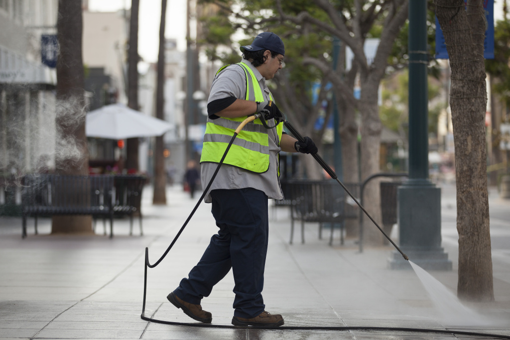 WATER 001 A Santa Monica city employee washes down the Promenade early Tuesday morning. The Promenade is pressured washed daily but much of the water is reclaimed and used to water local parks, a maintenance supervisor said.