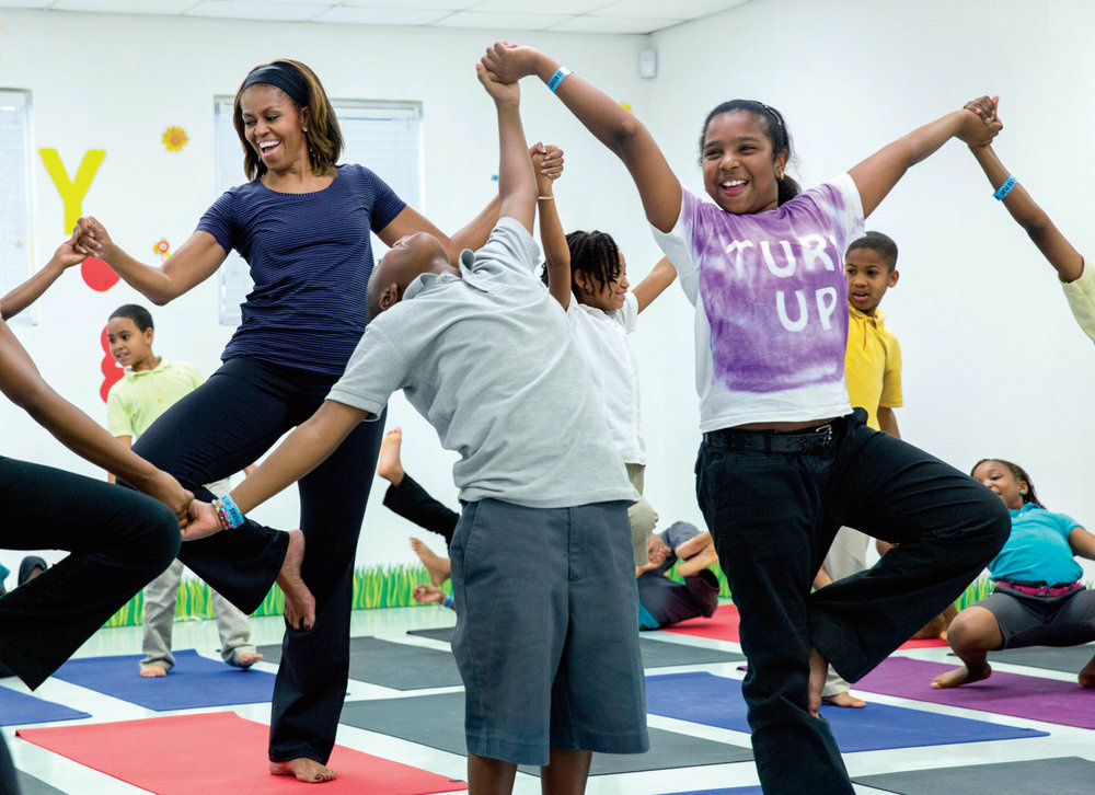 Michelle Obama First Lady Michelle Obama joins children for a yoga class during a Let's Move! after-school activities event at Gwen Cherry Park in Miami, Florida, February 25, 2014.