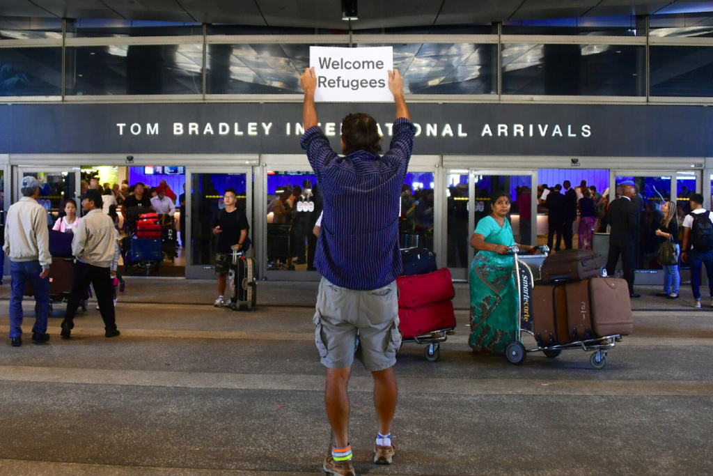 John Wider holds a sign that reads John Wider holds a sign that reads