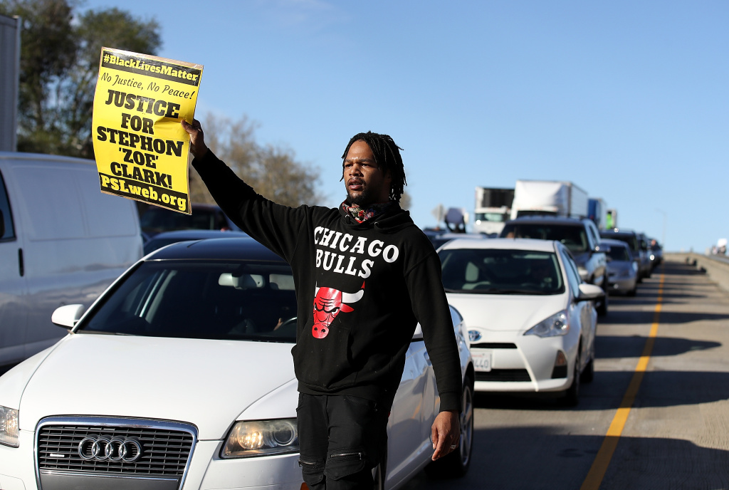 Demonstrators Protest Against Recent Sacramento Police Shooting Of Unarmed Black Man A Black Lives Matter protester holds a sign as he marches on Interstate 5 during a demonstration on March 22, 2018 in Sacramento.