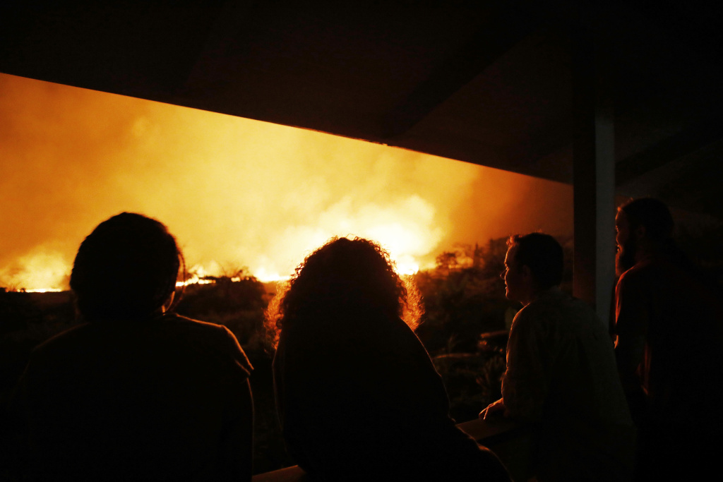 Hawaii's Kilauea Volcano Erupts Forcing Evacuations Residents view lava erupting from a Kilauea volcano fissure, at a small viewing party on a neighbor's porch, on Hawaii's Big Island on May 19, 2018 in Kapoho, Hawaii.