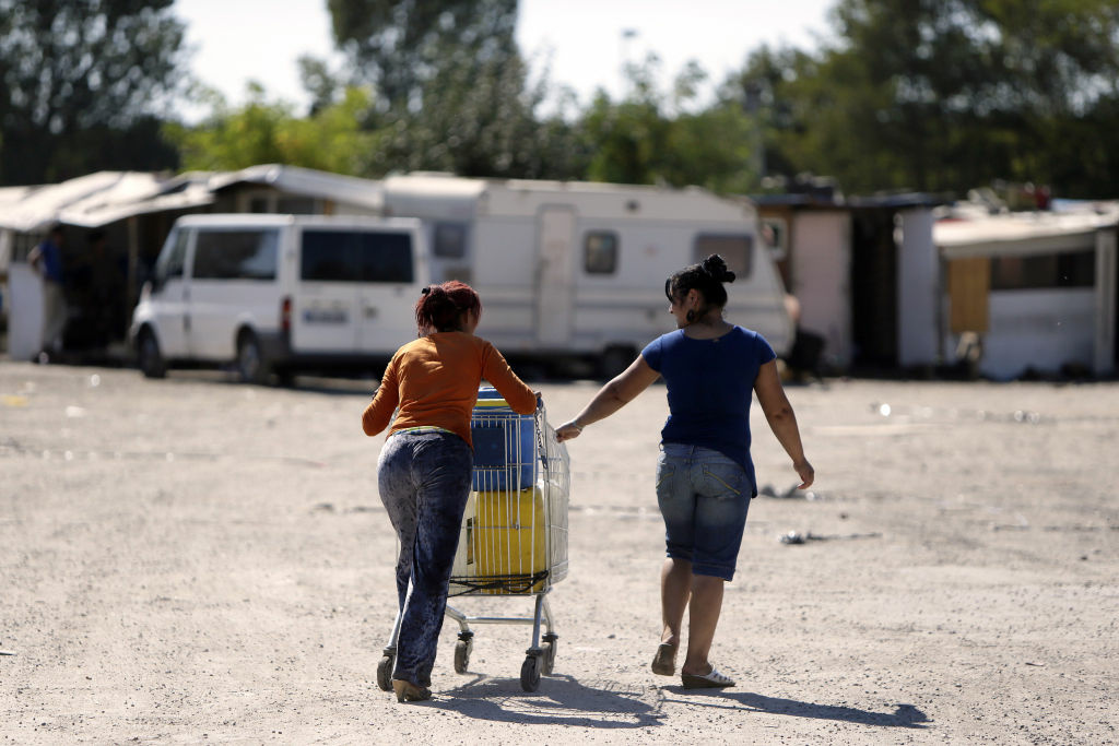 FRANCE-SOCIAL-IMMIGRATION-ROMA Women from the Roma community push a shopping trolley containing water toward their camp on September 9, 2012 in a camp in Sucy-en-Brie, near Paris.