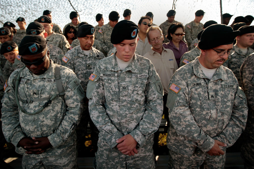 For Some Returning US Troops, PTSD Is The New Battlefield Soldiers with the 1st Infantry Division bow their heads in prayer before a deployment ceremony for another tour in Iraq August 13, 2009 at Fort Riley, Kansas.