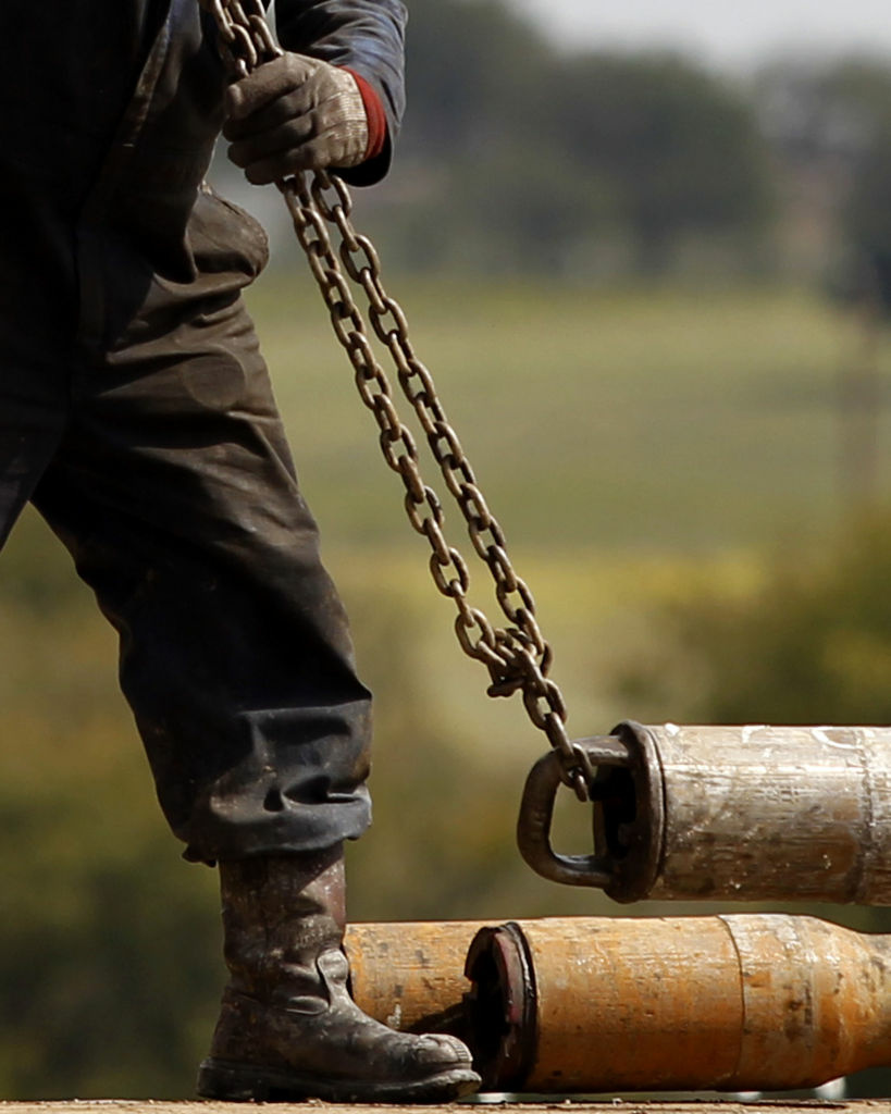 A worker hooks up pipe during natural gas drilling by EnerVest on the Barnett Shale near Fort Worth, Texas, in 2012.