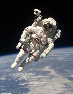 An astronaut floats in outer space.