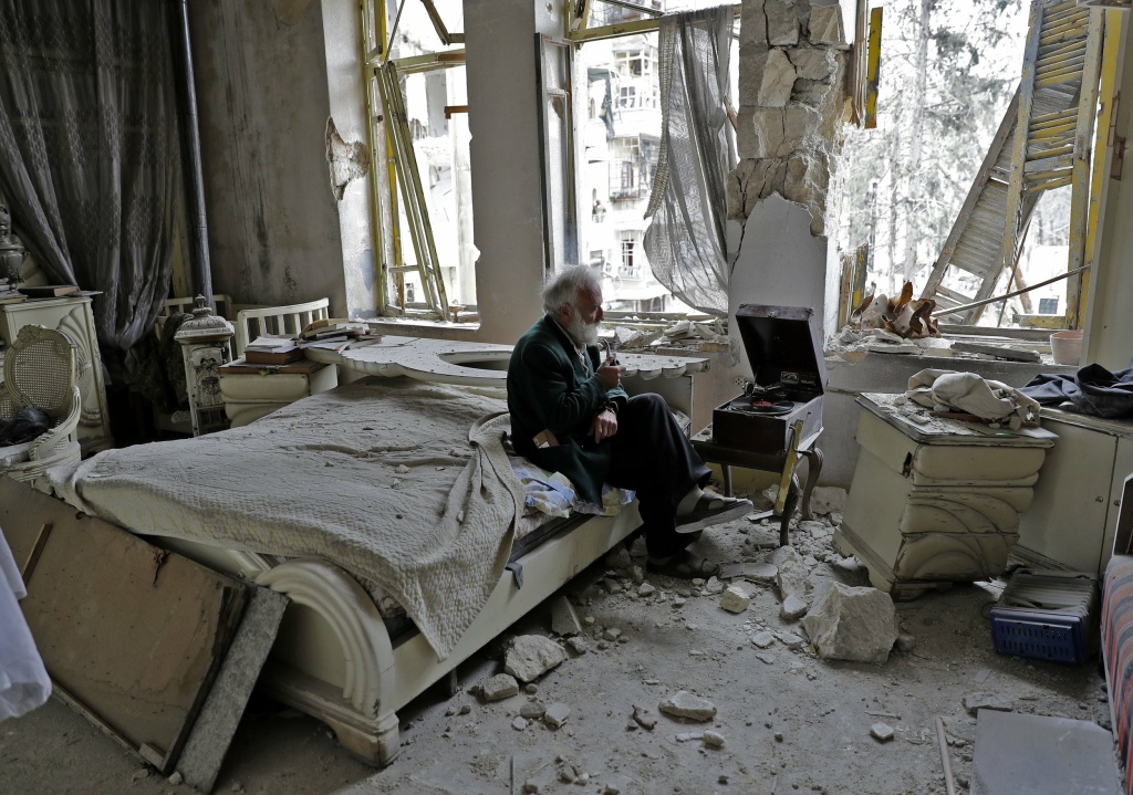 syria civil war Mohammed Mohiedin Anis, known as Abu Omar, 70, sits amid the rubble in his bedroom while listening to music on his gramophone in the formerly rebel-held al-Shaar neighborhood of Aleppo, Syria.
