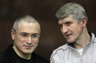 Mikhail Khodorkovsky, left, and his co-defendant Platon Lebedev, right, talk behind a glass enclosure at a court room in Moscow, Russia, Thursday, Dec. 30, 2010.