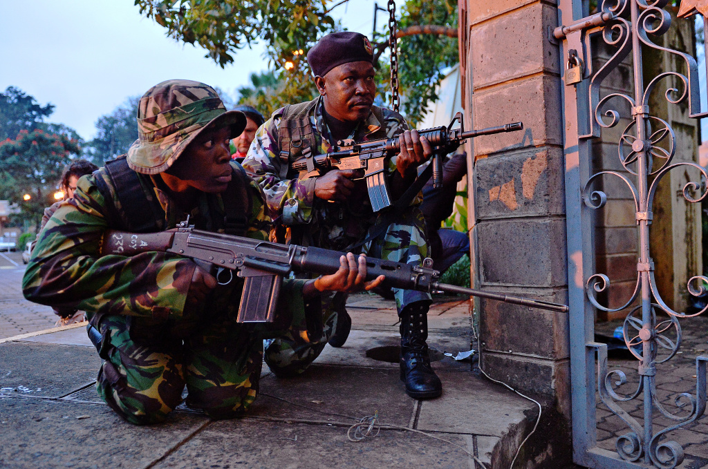 KENYA-ATTACKS-MALL Kenyan soldiers take cover after heavy gunfire near Westgate mall in Nairobi on September 23, 2013. Kenyan Defence troops remain inside the mall, in a standoff with Somali militants after they laid siege to the shopping centre shooting and throwing grenades as they entered. Somali Shebab militants on September 23 threatened to kill hostages they are holding in the Nairobi shopping mall as Kenyan troops move to end their siege.