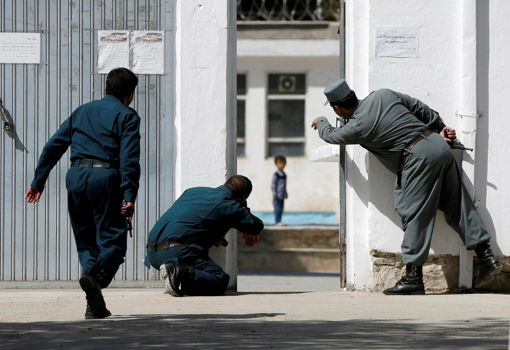 Kabul soldiers Afghan police gesture to four-year-old Ali Ahmad on Aug. 25 after a suicide attack on a Shiite mosque in Kabul.