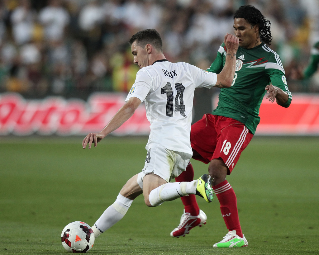 Storm Roux (L) of New Zealand is challenged by Carlos Pena of Mexico during their World Cup qualifying football match in Wellington on November 20, 2013. Mexico won 4-2.