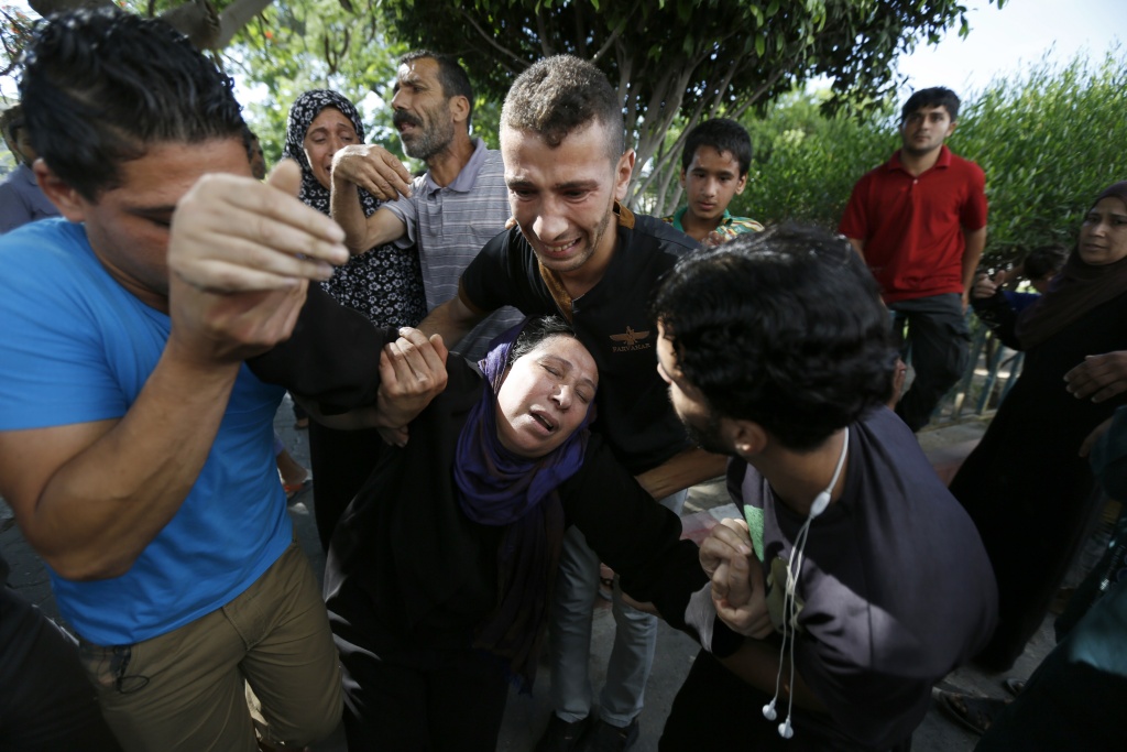 PALESTINIAN-ISRAEL-CONFLICT-GAZA The mother of one of the four boys, all from the Bakr family, killed during Israeli shelling, collapses outside the al-Shifa hospital in Gaza City, on July 16, 2014.