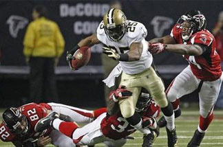 The Atlanta Falcons defense tries to take down New Orleans Saints running back Reggie Bush (25) in the first half of an NFL football game at the Georgia Dome in Atlanta on Monday, Dec. 27, 2010. Defending for Atlanta are Joe Zelenka (82), Ovie Mughelli (34) and Jason Snelling (44).