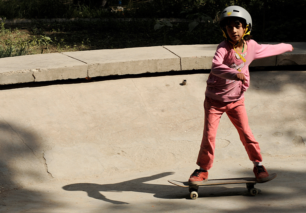 An Afghan girl rides a skateboard inside An Afghan girl rides a skateboard inside the bowl of an old concrete fountain during the celebration of International Go Skateboarding Day in Kabul on June 21, 2009.