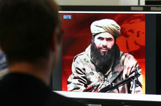 Mercer 12950 A man looks at a picture of Abdelmalek Droukdel alias Abou Moussaab Abdelouadoud, head of Al-Qaeda in the Islamic Maghreb (AQIM) seen on US monitoring group SITE Intelligence, on November 19, 2010 in Paris.