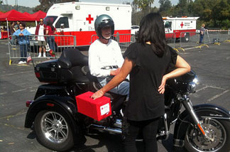 Motorcyclist donor Buzz Smith speaks with Red Cross volunteer at a drive-through donation stop for the Red Cross’ Japan Earthquake Tsunami Fund on March 14, 2011.