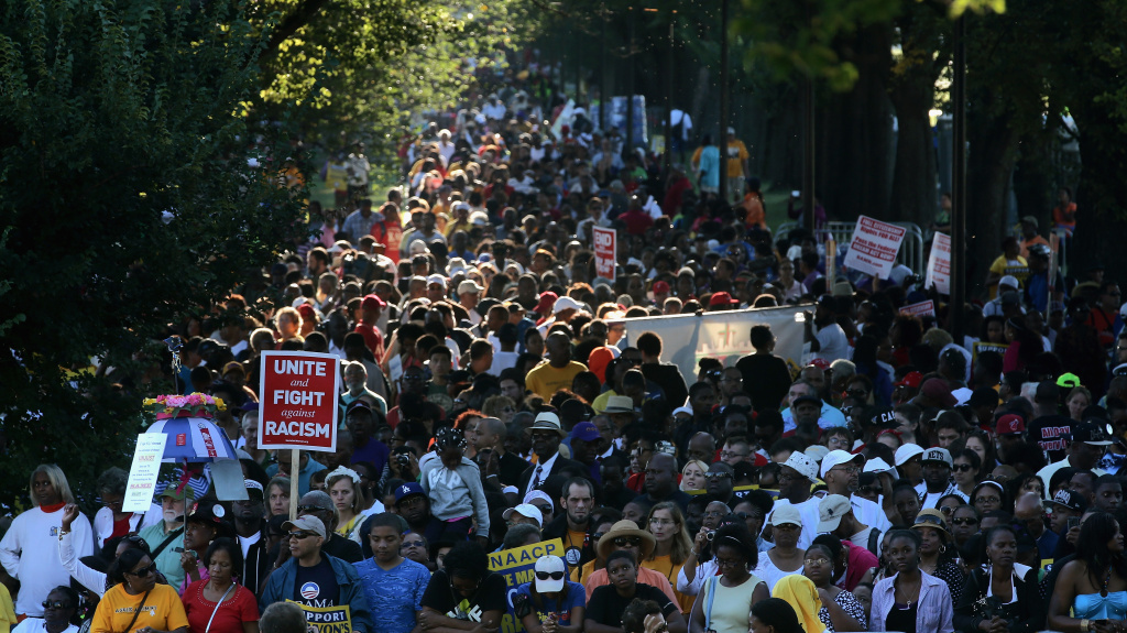 People hold signs as they gather to celebrate the 50th anniversary of the March on Washington. People hold signs as they gather to celebrate the 50th anniversary of the March on Washington.