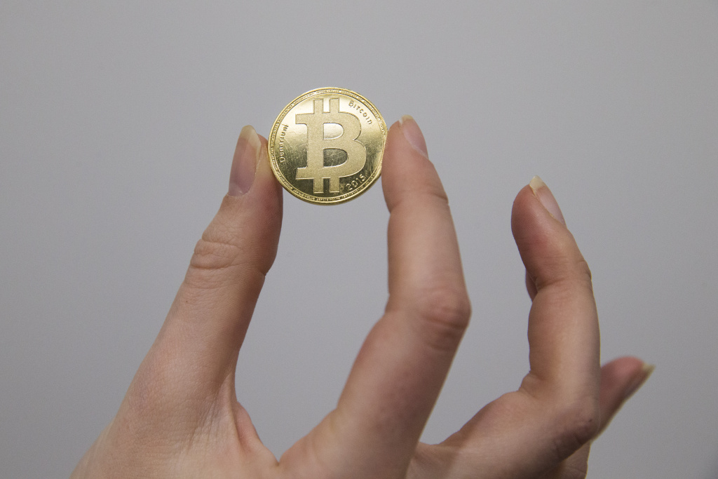FRANCE-BITCOIN A person holds a visual representations of the cryptocurrency Bitcoin, at La Maison du Bitcoin in Paris on January 17, 2018.