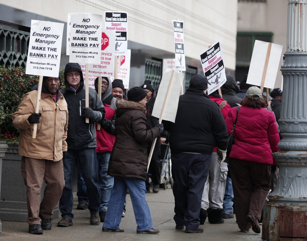 People protest outside the U.S. Courthouse where federal bankruptcy Judge Steven Rhodes is to rule on Detroit's Chapter 9 bankruptcy eligibility Dec. 3, 2013 in Detroit, Michigan. Detroit is the largest city in U.S. history to file for bankruptcy.