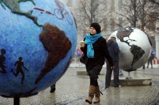 A woman walks between displays, entitled 'Cool Globes,' an exhibition about combating global warming and climate change.