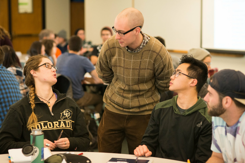 Learning assistant Michael Byars (standing) talks with (from left) students Anna Eydinova, Aaron Higa and Austin Reed during an evolutionary biology class. Learning assistant Michael Byars (standing) talks with (from left) students Anna Eydinova, Aaron Higa and Austin Reed during an evolutionary biology class.