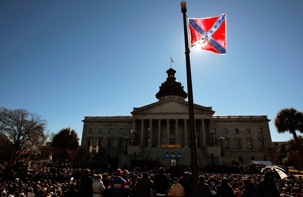 A Confederate flag that's part of a Civil War memorial on the grounds of the South Carolina State House flies during a Martin Luther King Day rally in 2008. The state is under fire for continuing to fly the flag. A Confederate flag that's part of a Civil War memorial on the grounds of the South Carolina State House flies during a Martin Luther King Day rally in 2008.