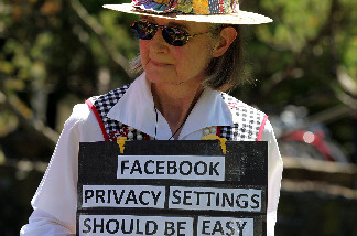 Mary Guedon of the group Raging Grannies holds a sign as she protests outside of the Facebook headquarters June 4, 2010 in Palo Alto, California.