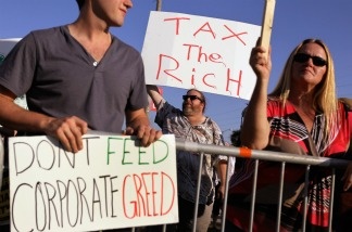 Mercer 21210 Craig Glaser holds a sign reading, 'Tax the Rich,' outside the building where the Republican presidential debate sponsored by CNN and The Tea Party Express is being held at the Florida State fairgrounds on September 12, 2011 in Tampa, Florida.