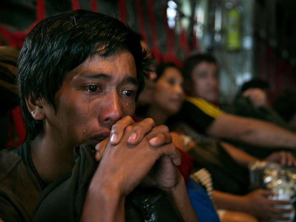 In anguish: Tears ran down the cheeks of a man as he waited with other survivors Tuesday for a flight out of Tacloban, the Philippines, which was devastated by Typhoon Haiyan. In anguish: Tears ran down the cheeks of a man as he waited with other survivors for a flight out of Tacloban, the Philippines, which was devastated by Typhoon Haiyan.