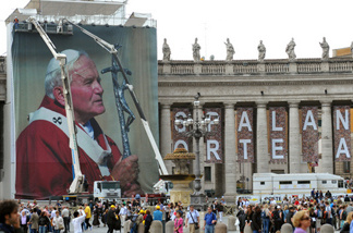 Workers set up a giant photo of the late Pope John Paul II at St. Peter's Square on April 27 at the Vatican. John Paul II will be honored May 1 at a beatification ceremony.