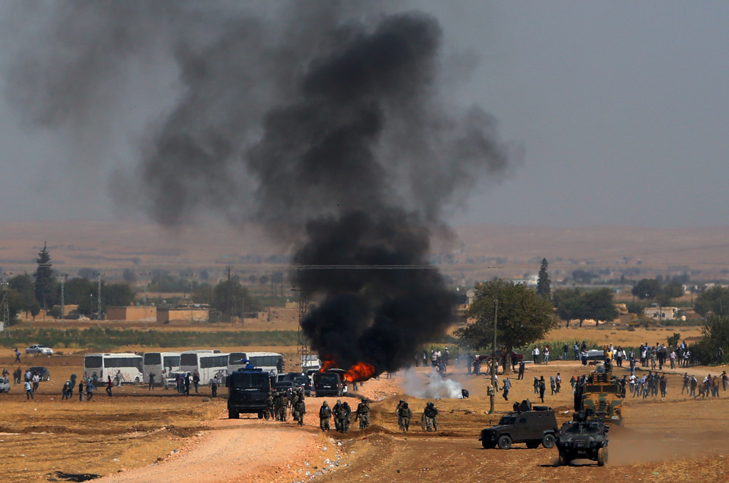 Turkey Syria Refugees A car hit by a teargas canister burns as riot police use teargas to disperse Kurdish demonstrators as thousands of Syrian refugees continue to arrive at the border in Suruc, Turkey, Monday, Sept. 22, 2014. A new tracking system has found that nearly one in five ammunition cartridges found on Islamic State fighters were actually made in the US.