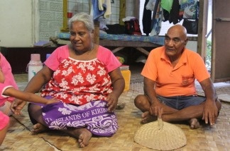 Batie Tebwa and Baure Karakaua sit on the floor of their home in Kiribati. Their daughter, Tiibea Baure, has repeatedly tried to convince them that climate change is a threat, but they don't believe in it.