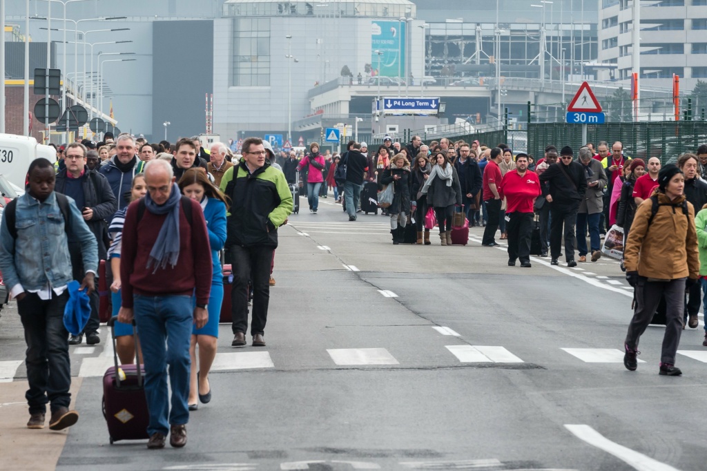 Belgium Airport People walk away from Brussels airport after explosions rocked the facility in Brussels, Belgium Tuesday March 22, 2016. Explosions rocked the Brussels airport and the subway system Tuesday, just days after the main suspect in the November Paris attacks was arrested in the city, police said. (AP Photo/Geert Vanden Wijngaert)