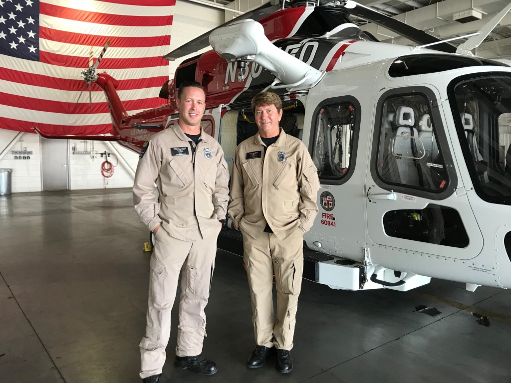 Pilots Joel Smith, left and David Nordquist, right, stand in front of their helicopter at the Los Angeles Fire Department air operations base in Van Nuys. (Emily Dugdale/KPCC) Pilots Joel Smith, left and David Nordquist, right, stand in front of their helicopter at the Los Angeles Fire Department air operations base in Van Nuys. (Emily Dugdale/KPCC)