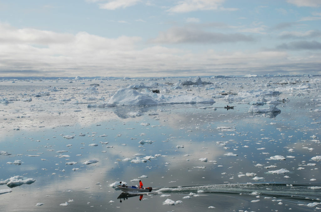 DOUNIAMAG-FILES-GREENLAND-ENVIRONMENT-GLACIER A picture taken on July 3, 2009 shows a fisherman sailing on the Ice Fjord of Ilulissat in Greenland. The Greenland ice sheet has lost 1,500 billion tonnes of ice since 2000, contributing 0.75 mm (0.03 inch) annually to sea levels, according to a study published in December 2009. Some experts believe the Arctic ice cap will disappear completely in summer months within 20 to 30 years.
