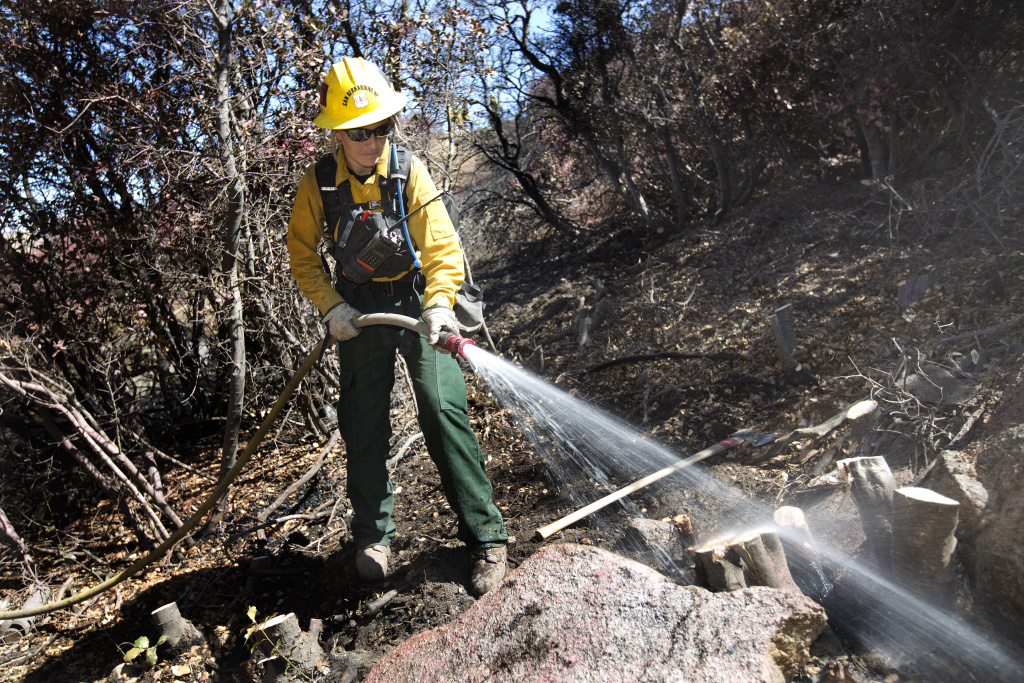 Pilot Fire profile Firefighter Nicole White works tp protect a home from the Pilot Fire burning in Hesperia, California on August 9th, 2016.