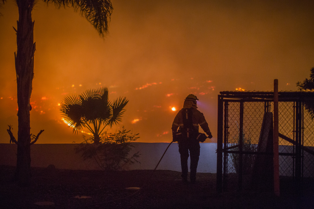 Southern California Wildfires Forces Thousands to Evacuate A firefighter guards a house at the Lilac Fire on December 7, 2017 near Bonsall, California.