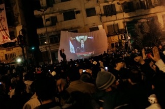 Protesters watch Egyptian president Hosni Mubarek give a speech on a projected television screen in Tahrir Square on Feb. 1, 2011 in Cairo, Egypt. In a pre-recorded televised address to the country, President Mubarak announced that he would not run for another term in office.